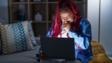 非裔美国女性编织头发使用电脑笔记本电脑晚上感觉不舒服,咳嗽感冒或支气管炎症状。